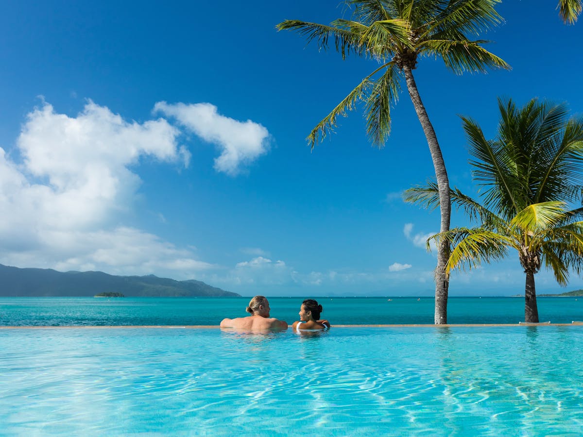 A couple enjoying the ocean views from an infinity pool