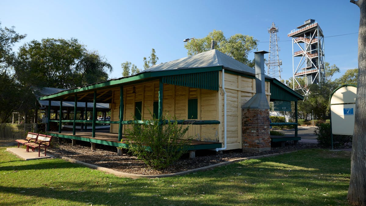 Exterior shot of a white wooden building with green trim