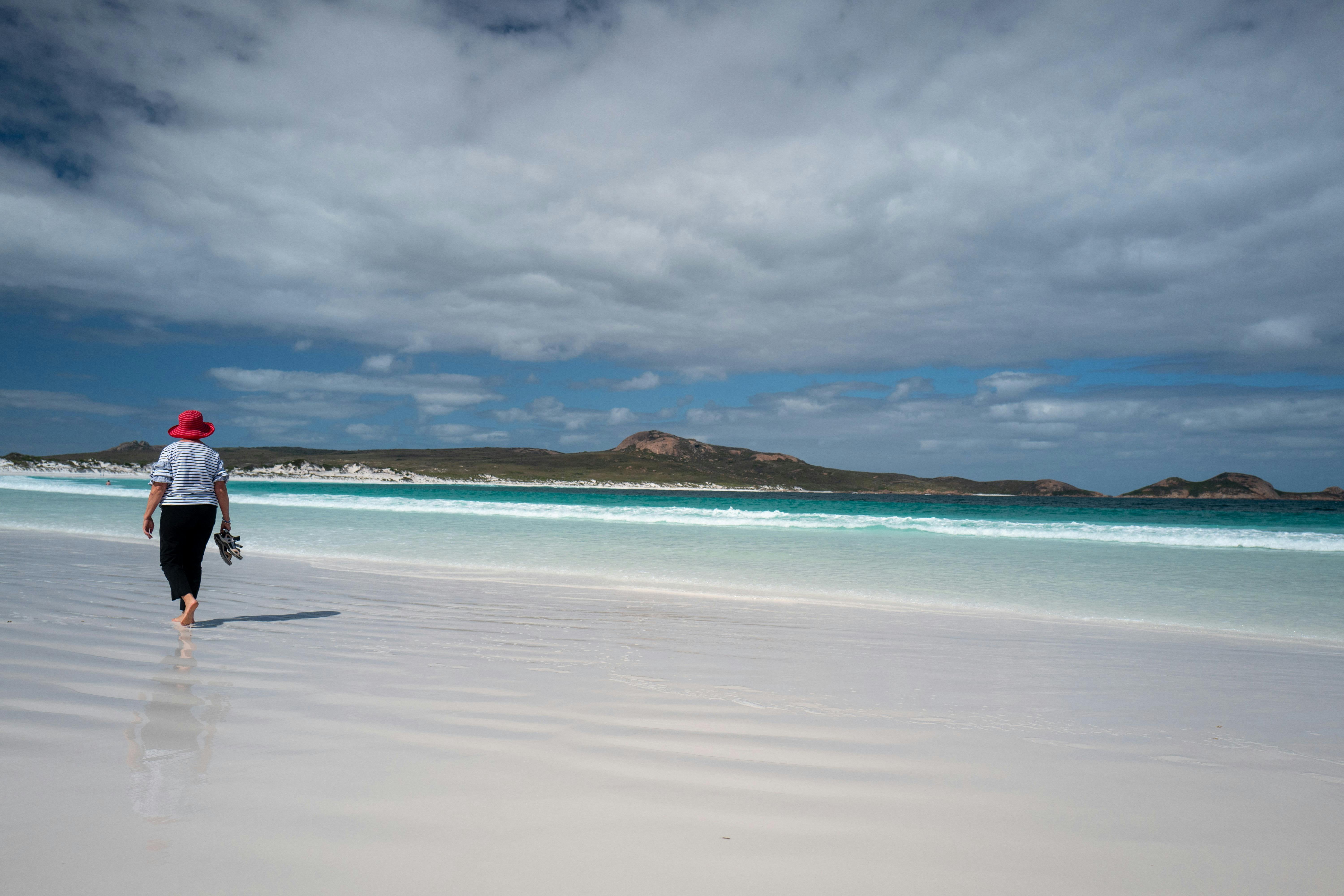Woman walking barefoot along a beautiful beach