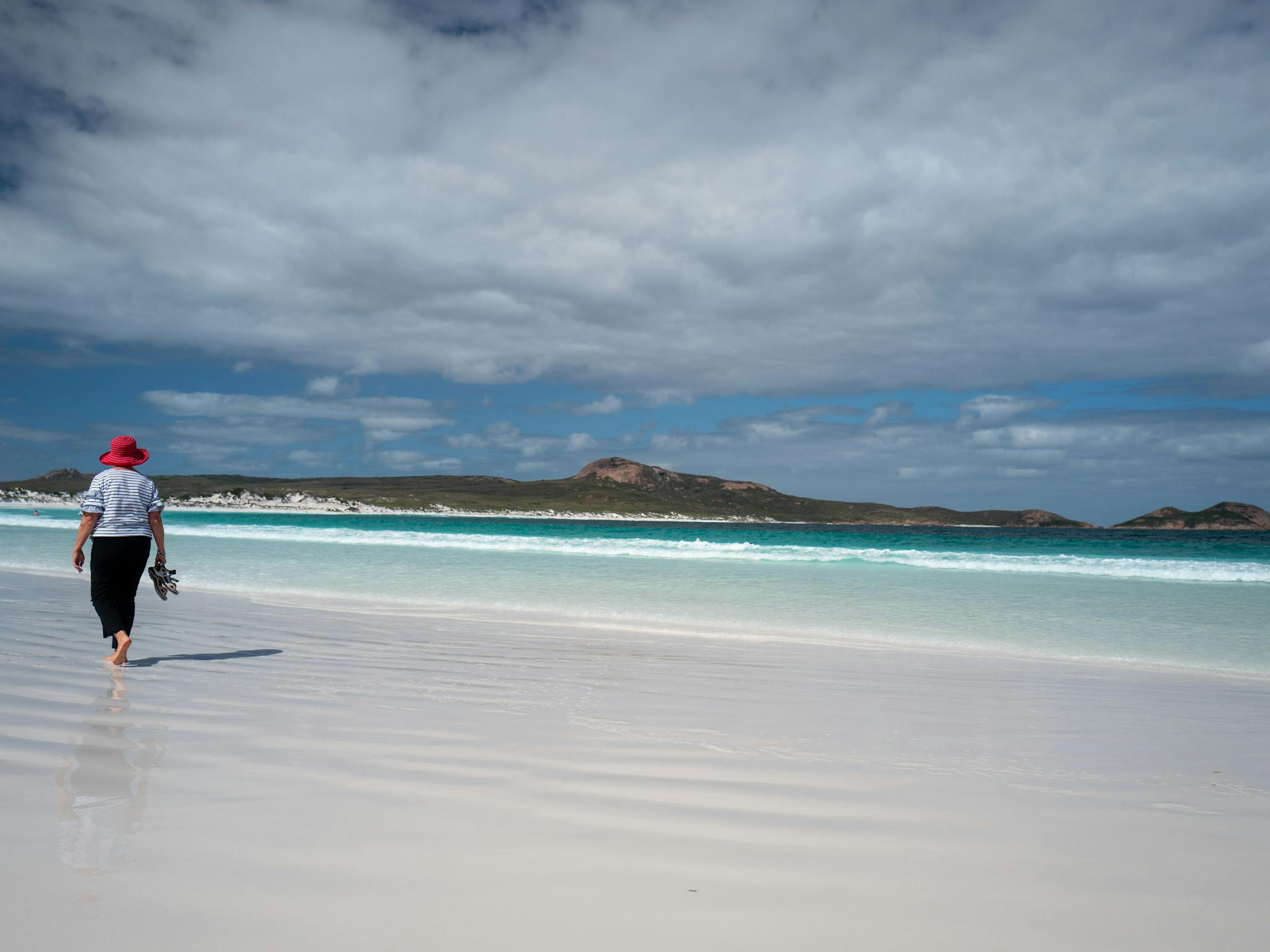 Woman walking barefoot along a beautiful beach