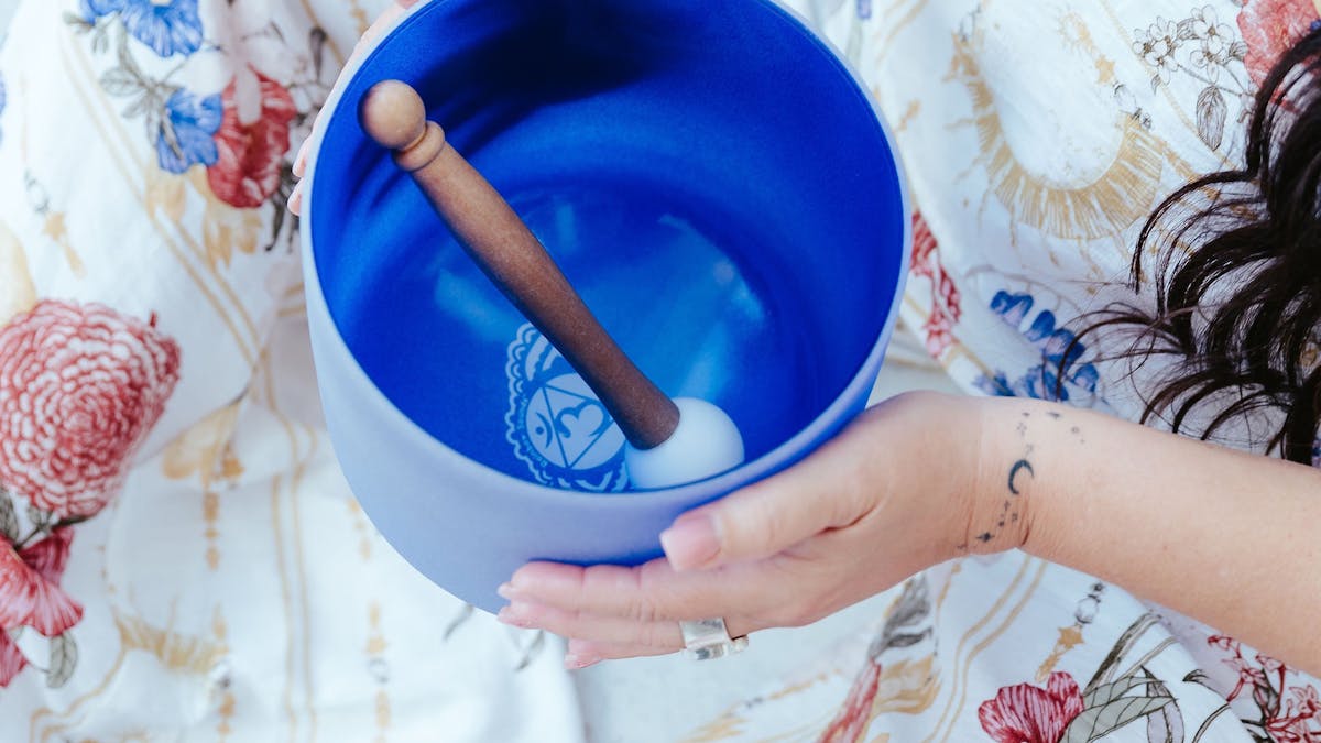 Sandy holding her blue crystal singing bowl with the mallet placed inside Sandy holding her blue crystal singing bowl with the mallet placed inside