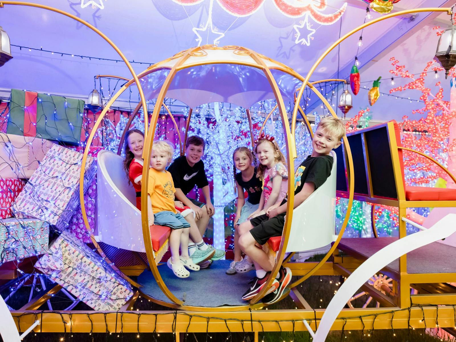A group of children sit in a carriage