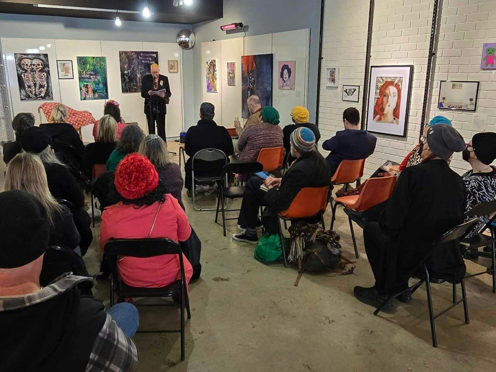 people sitting in room watching spoken word event