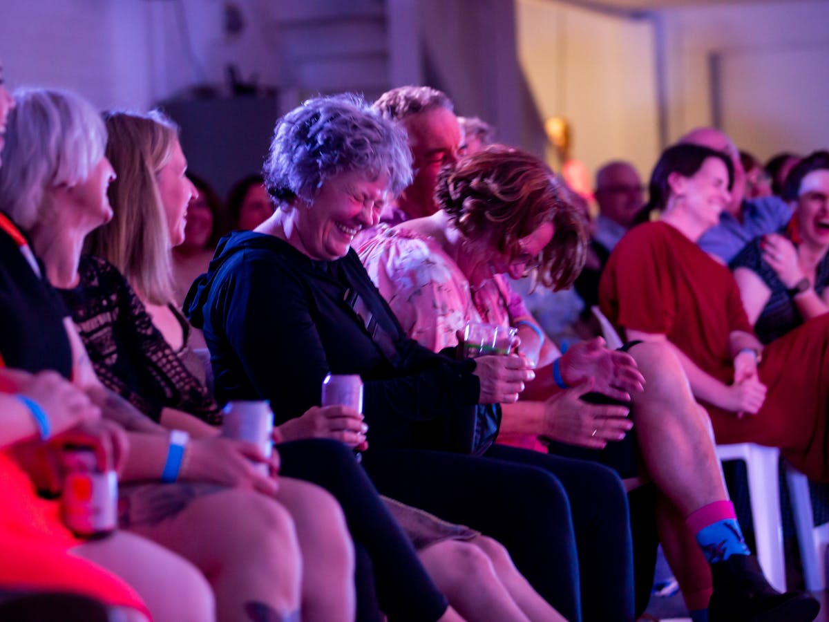 Seated audience members laughing at show