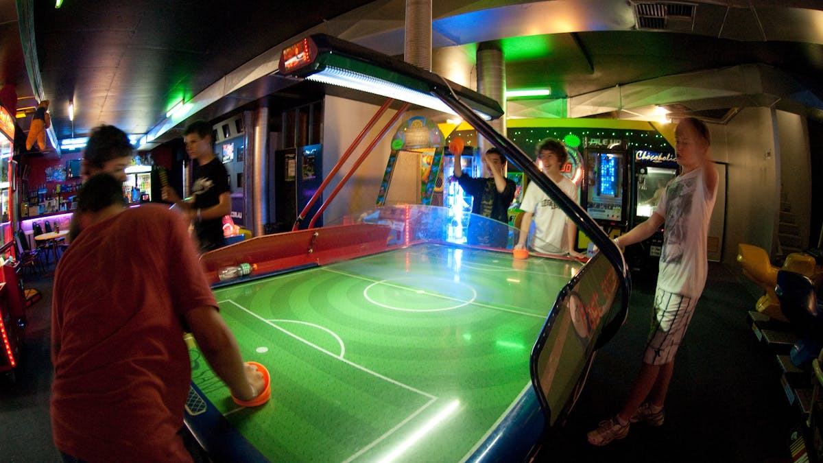 Group of teenagers cheering while playing air hockey at Laserzone Sunshine Coast