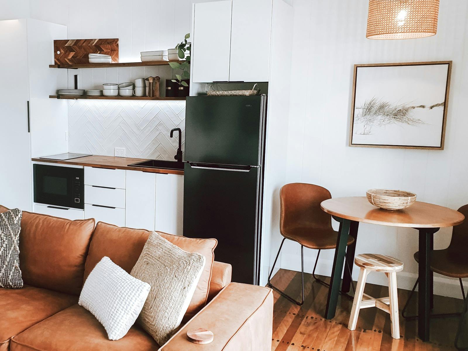 View of kitchen in Saltwater Apartments building which shows couch in foreground and dining table