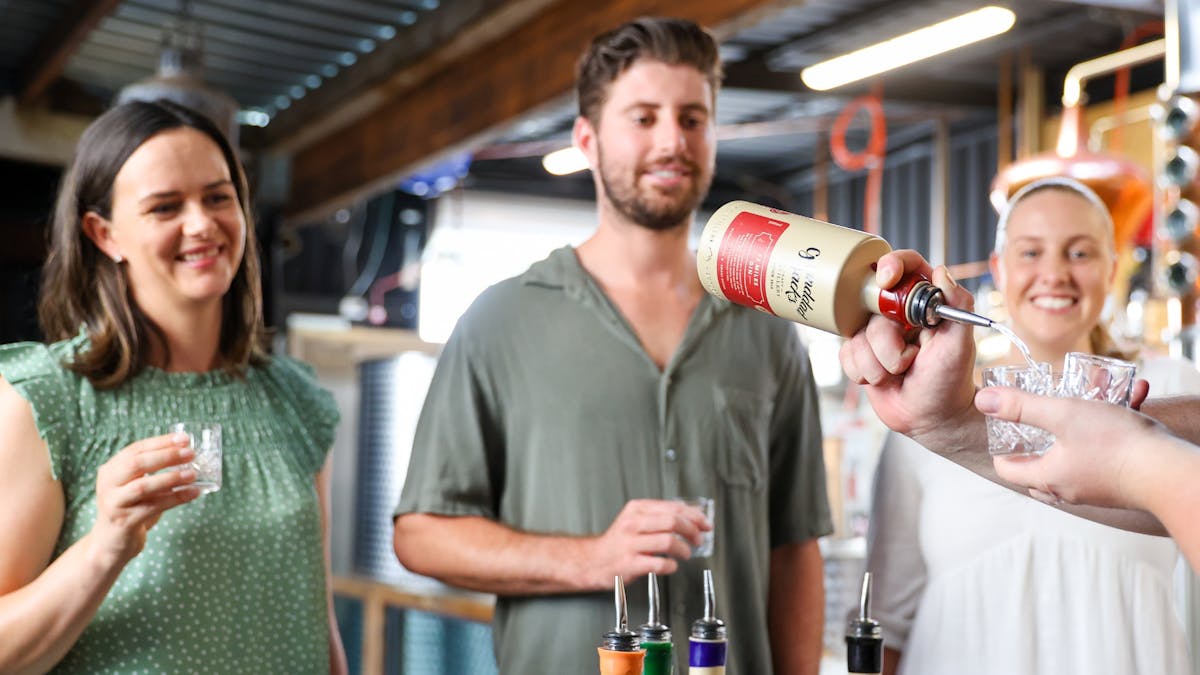 Pouring a tasting of 65 Miles for guests on a distillery tour.