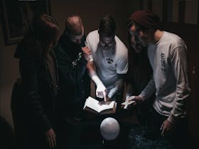 People looking at an item in a dark room trying to solve a mystery