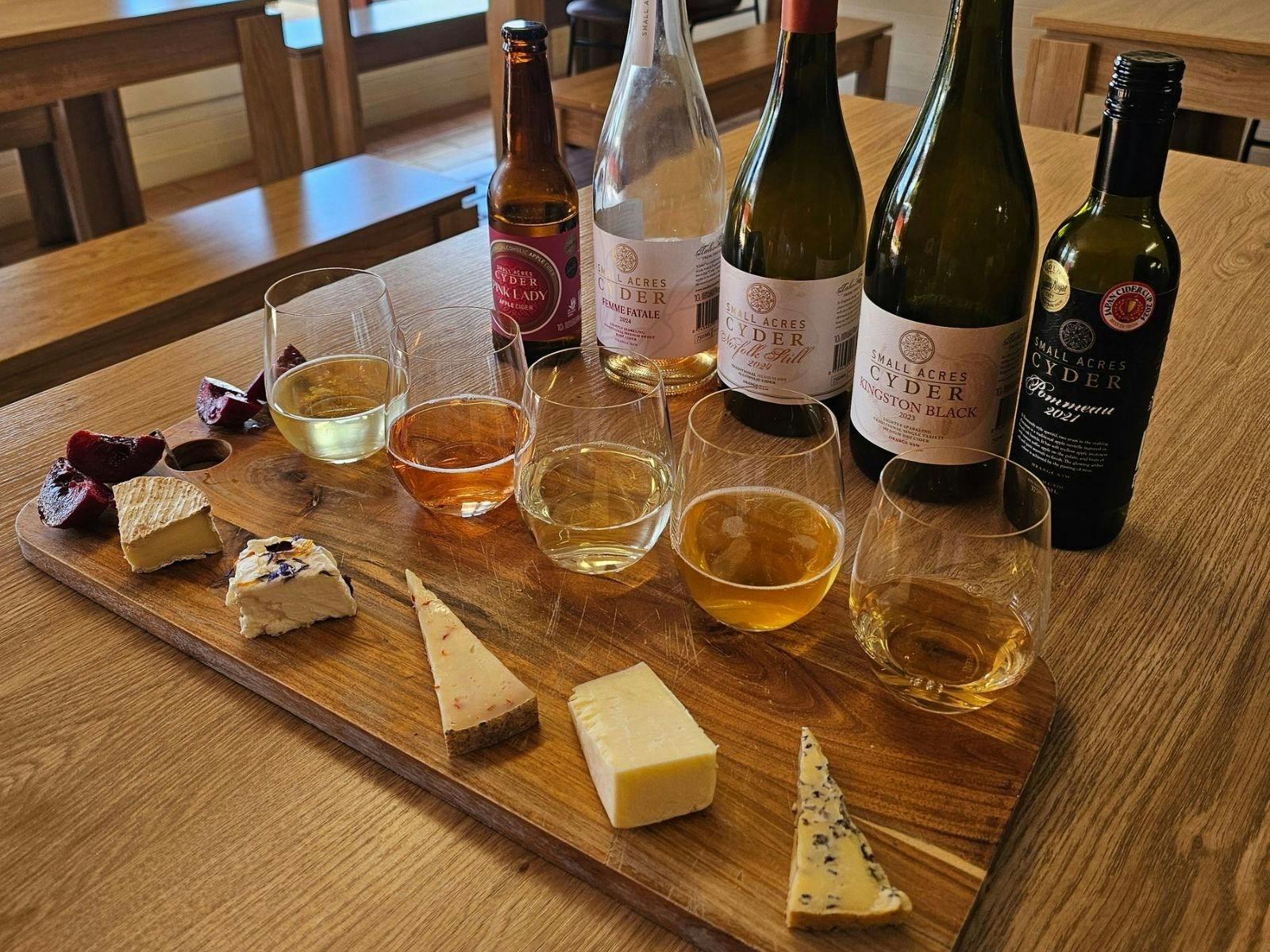 A row of artisan cheeses and vintage ciders