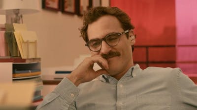 Man with moustache and glasses looking content smiling and looking down