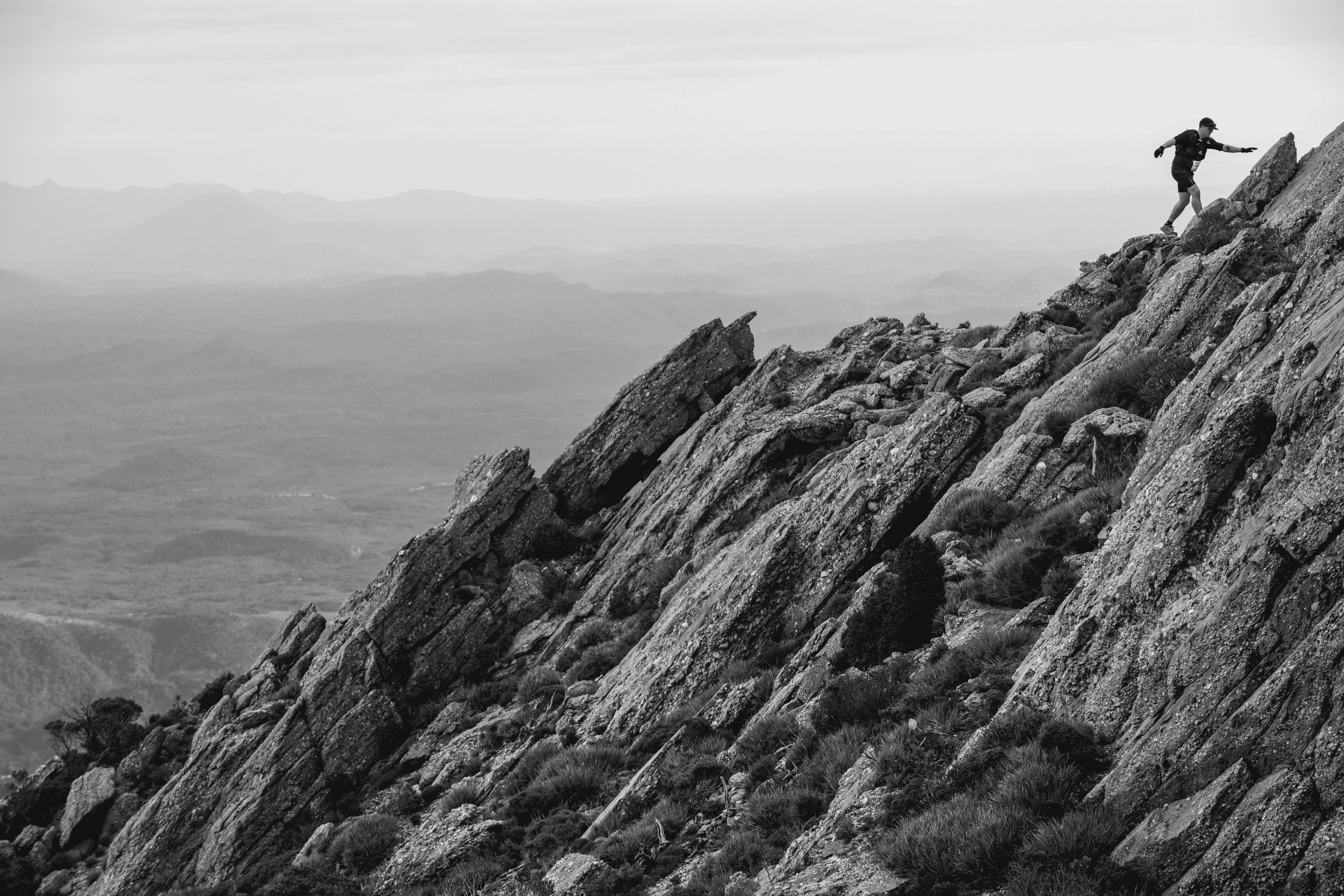 A male runner scales the rocky ridgeline