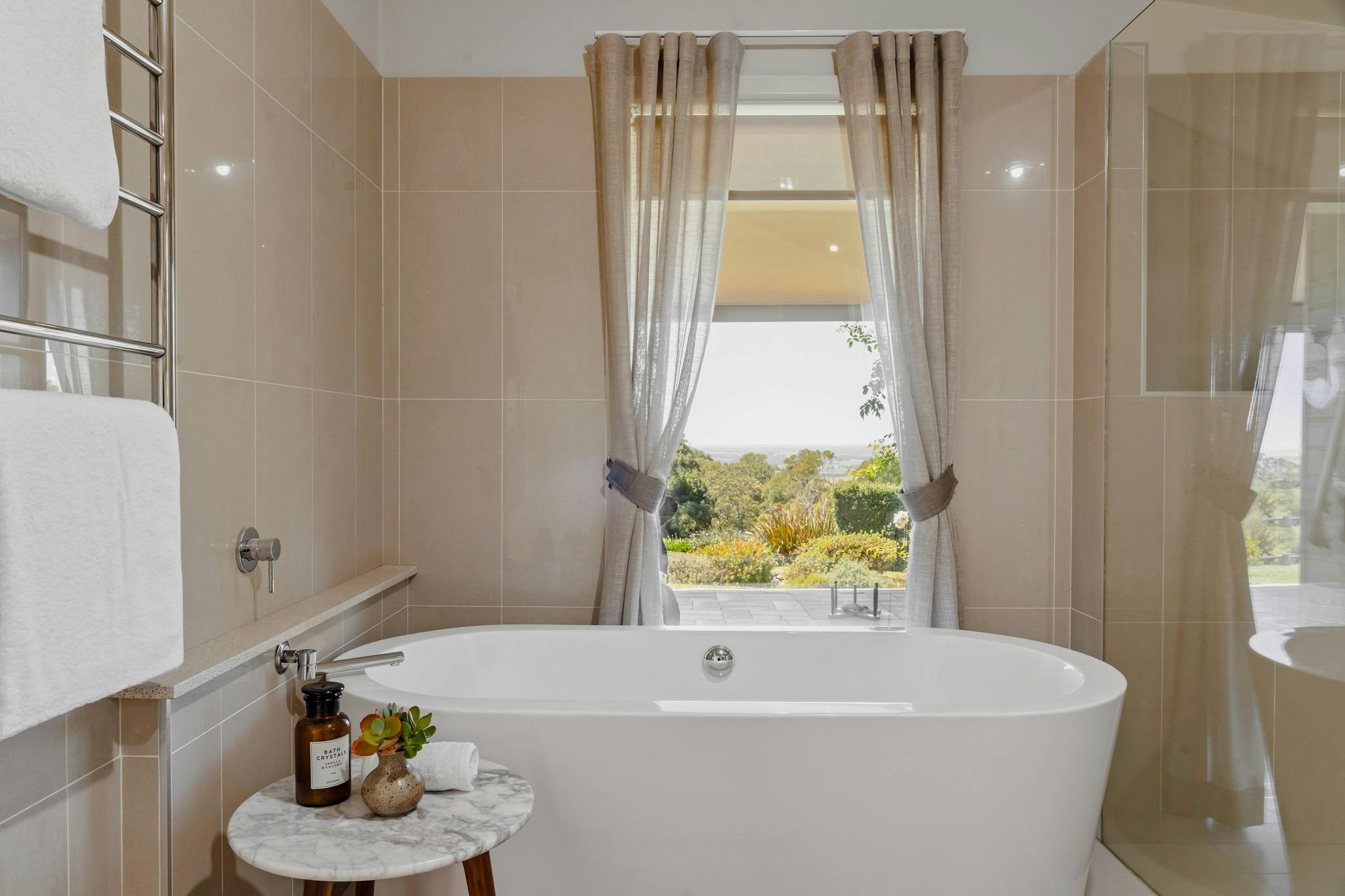 bath, bathsalts, curtains framing view from window