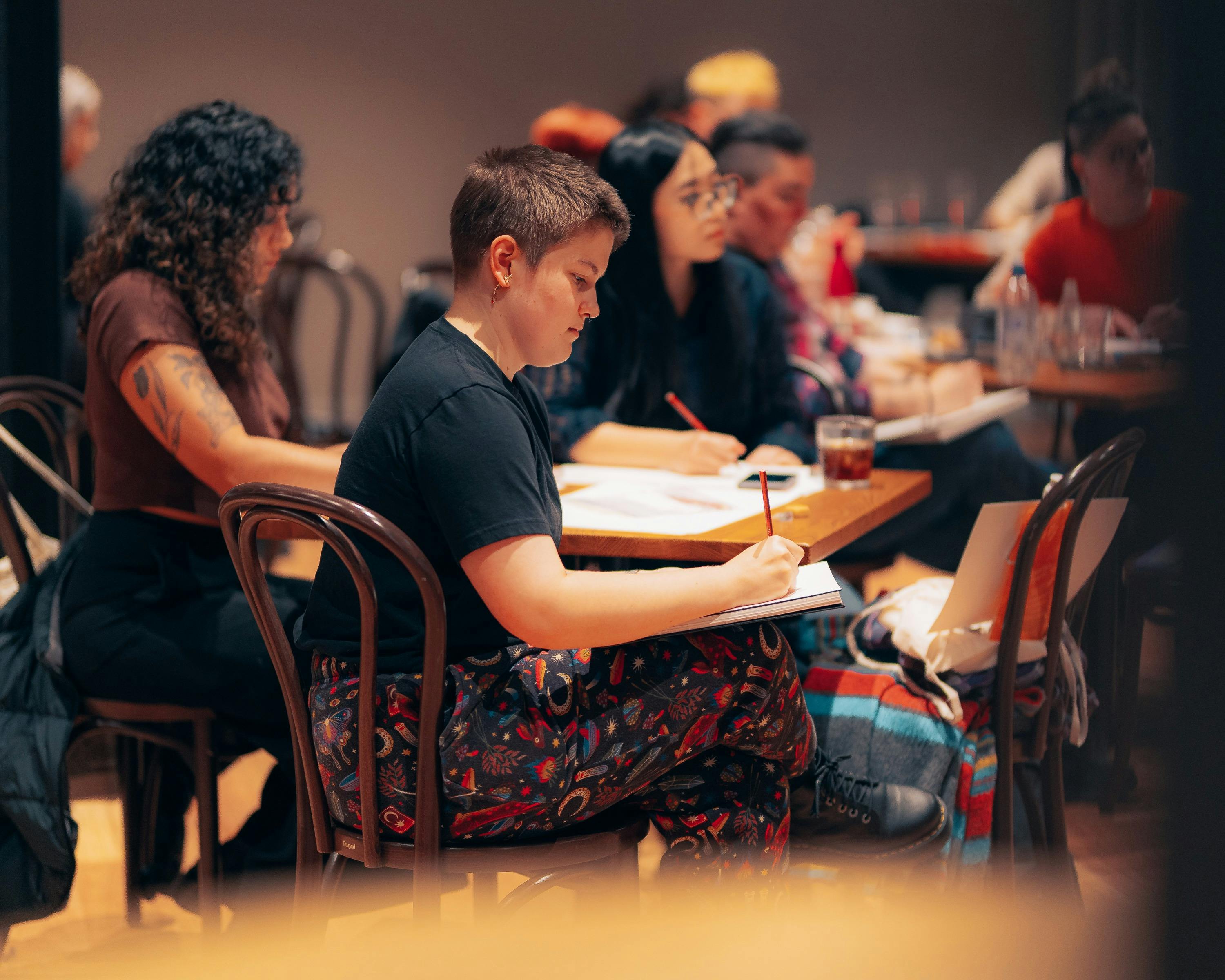 Group of people sitting around a table drawing