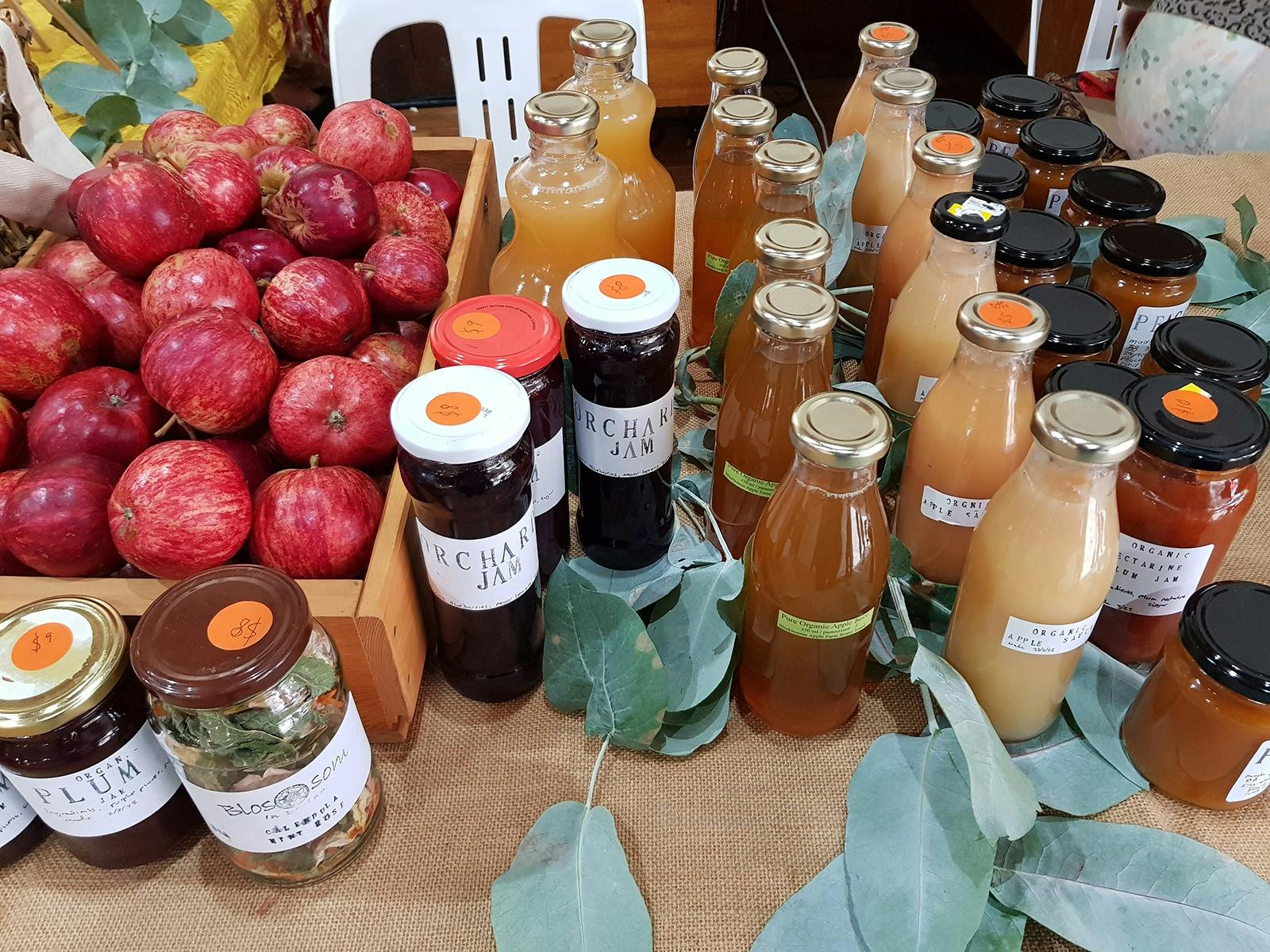 fresh apples, jams, preserves all displayed on a market stall