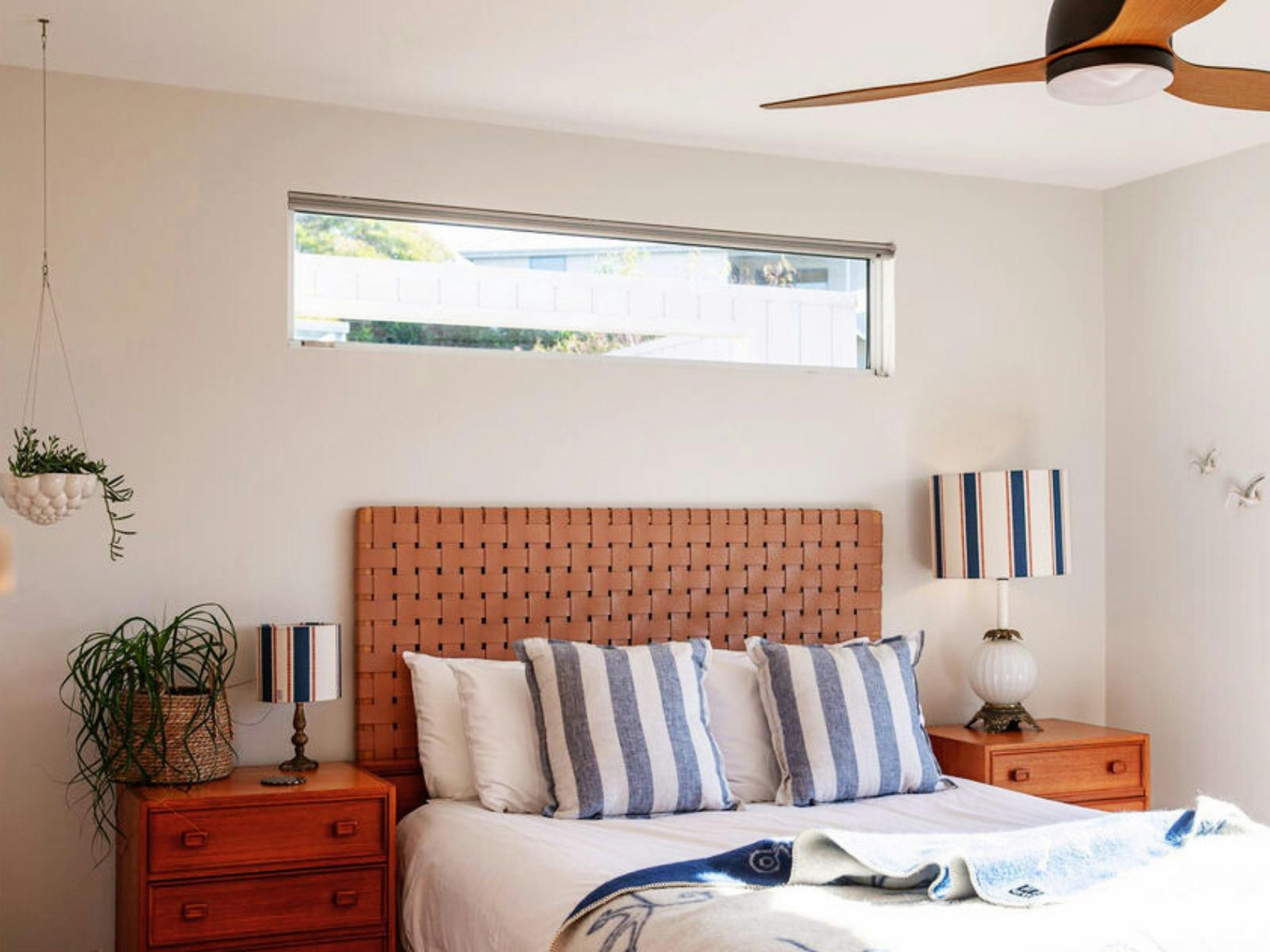 Bedroom - Sun soaked with view to Skeleton Bay. Queen Bed, bedside lamps and tables, plus plants.