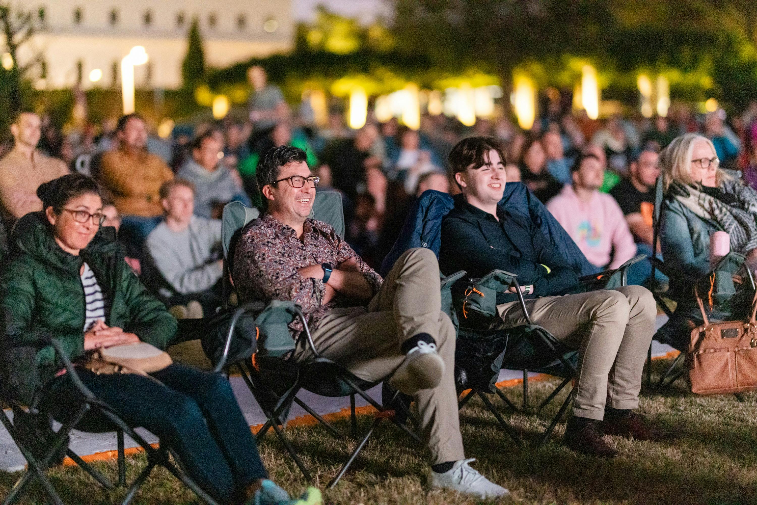 Crowd looking on, watching film festival in outdoor venue