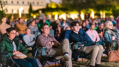 Crowd looking on, watching film festival in outdoor venue