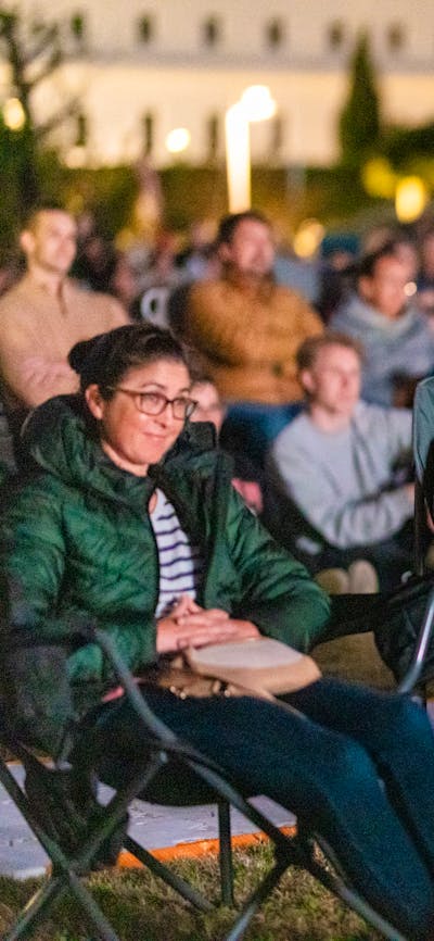 Crowd looking on, watching film festival in outdoor venue