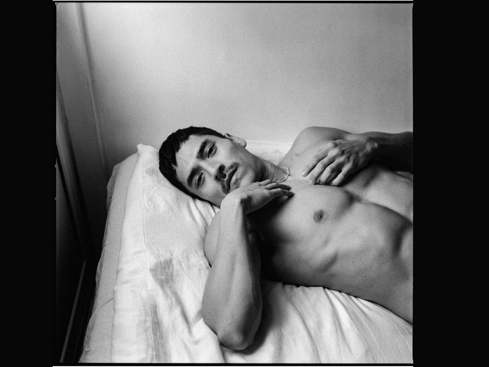 Photograph of a young man lying on the bed