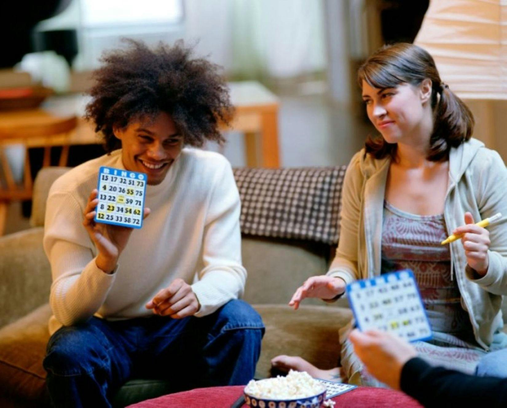 Image of two people gathered around a table playing bingo