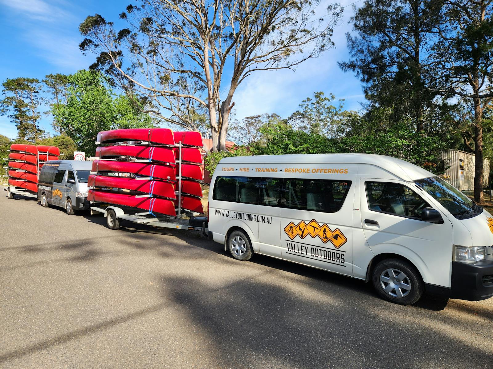 van towing a trailer of canoes