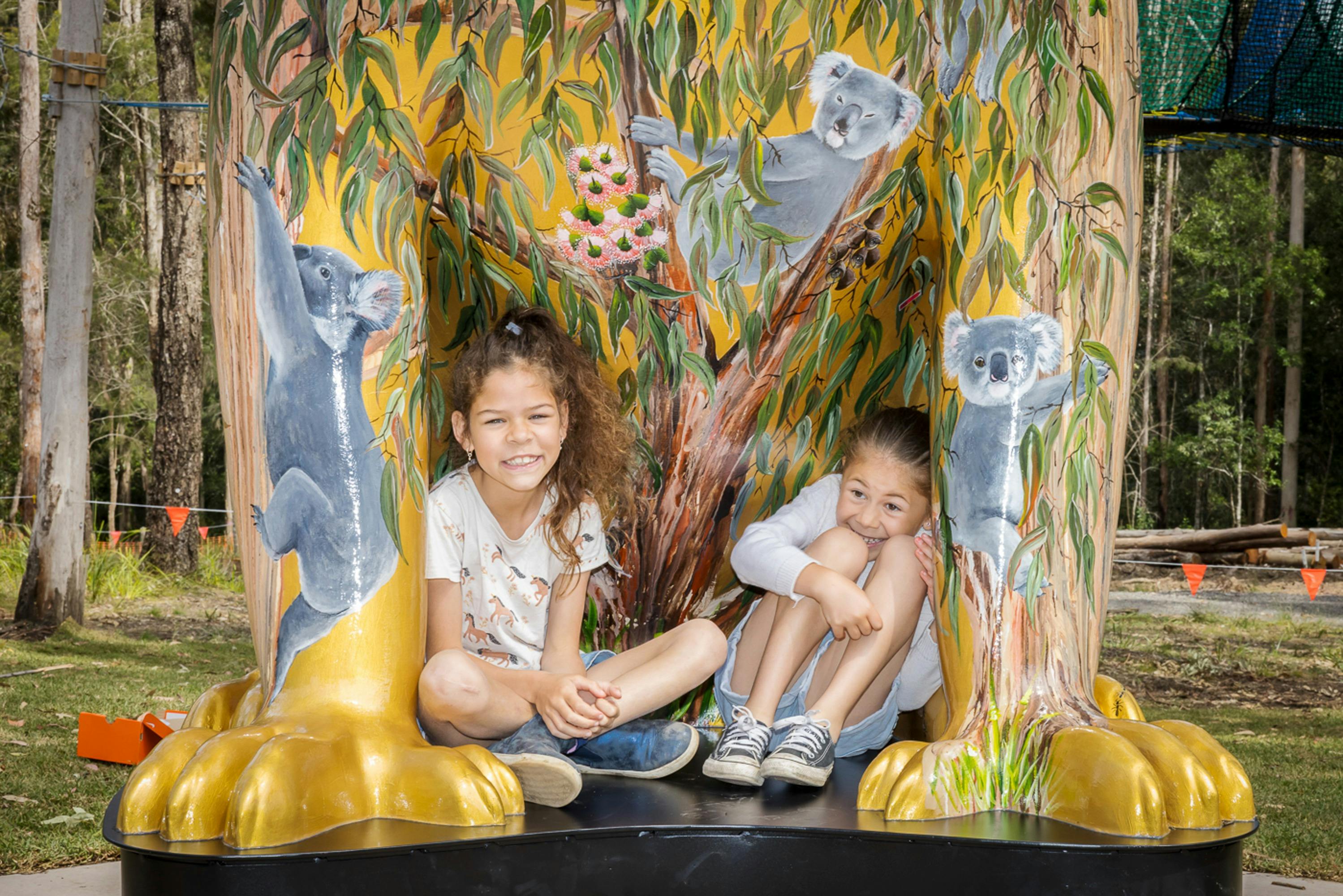 Children nestle at the feet of The Big Koala sculpture
