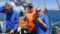 Crew and guest after hoisting sail on Ocean free