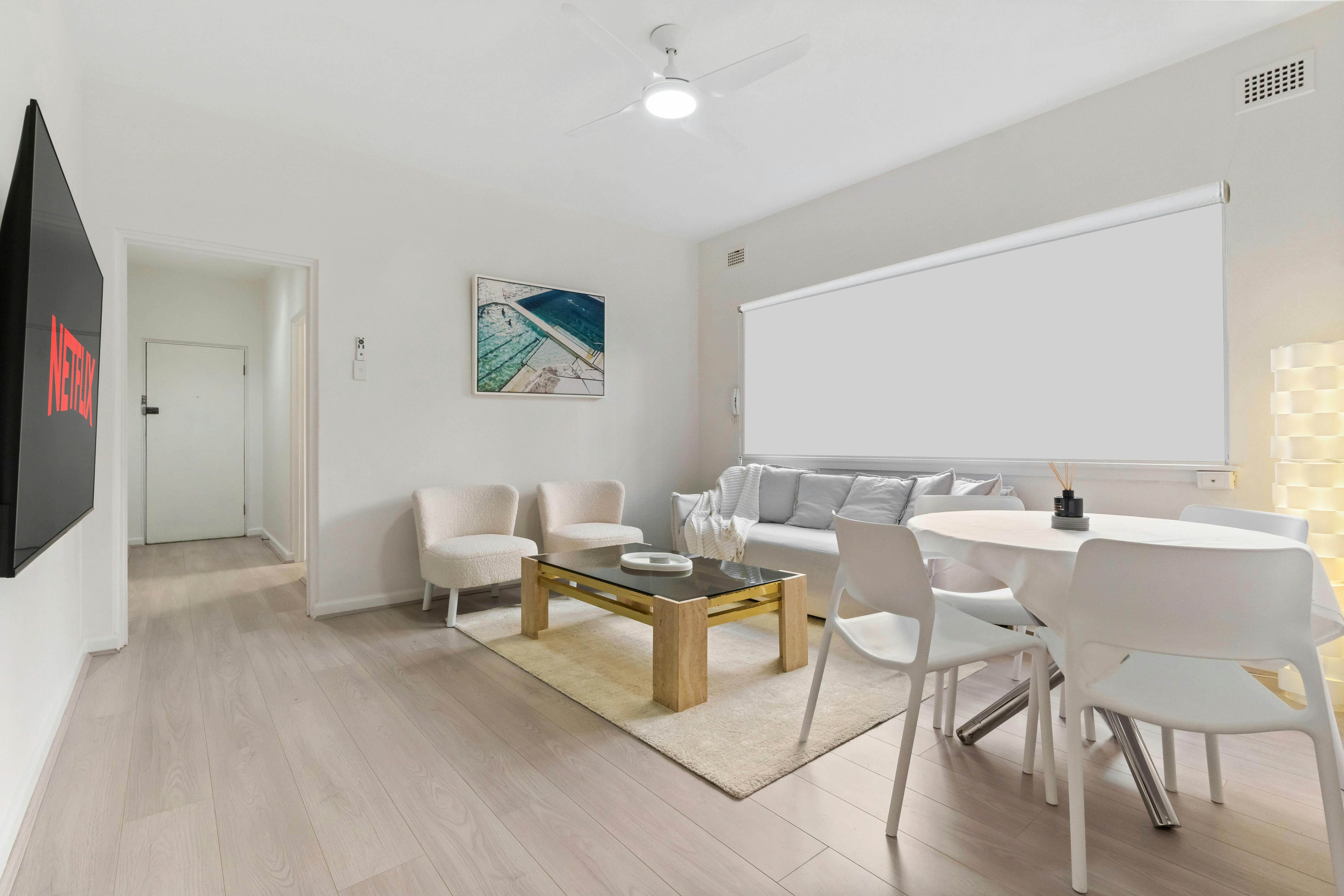 舒適的客廳配有沙發、椅子和牆面藝術。