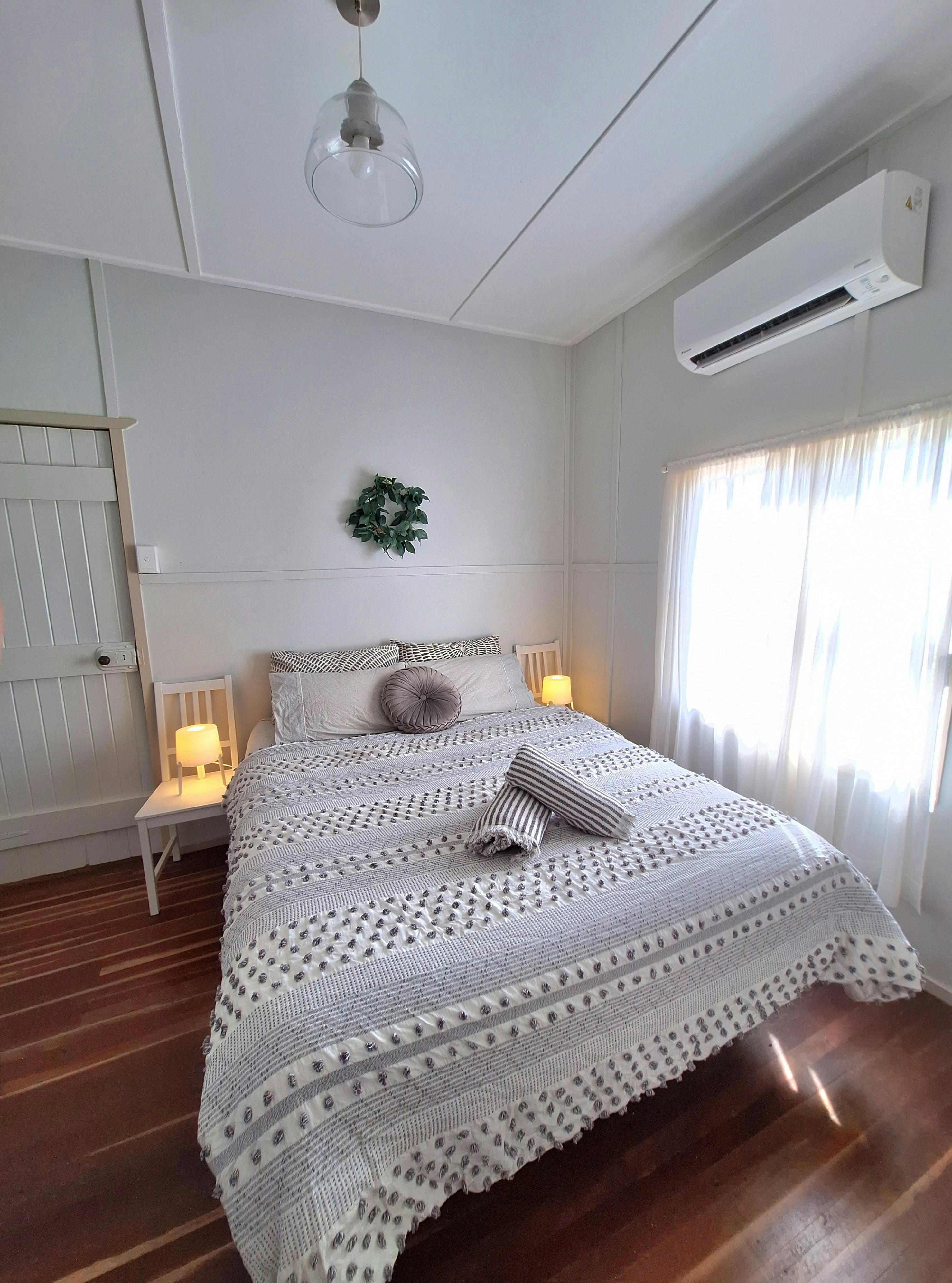 A double bed with towels placed at the foot of the bed