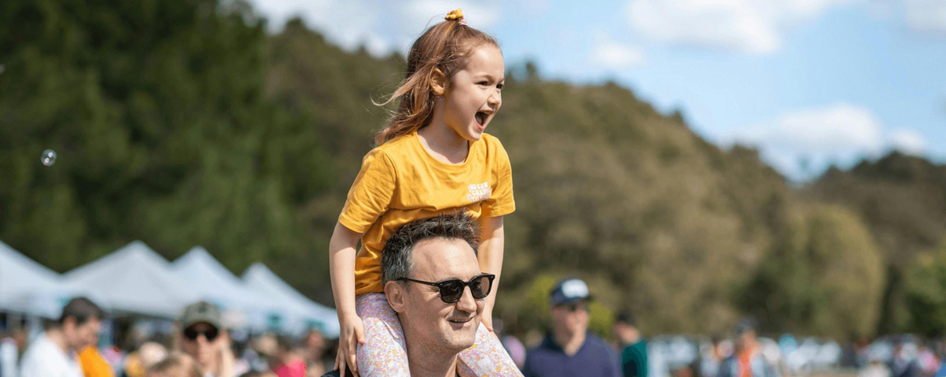 Child on father's shoulders outdoors