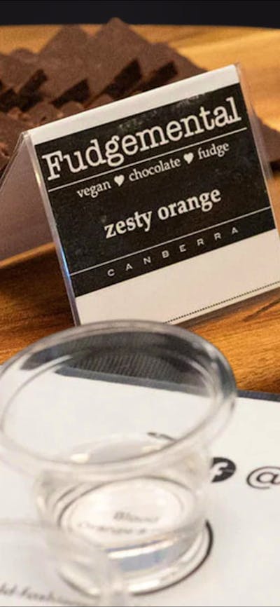 fudge on a wooden platter and tasting glasses of gin