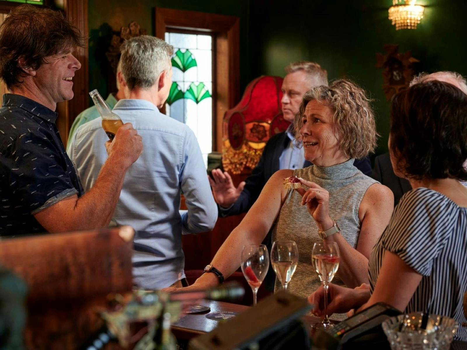 Two people talk and laugh whilst enjoying drinks and food at the Stanley Wine Bar.