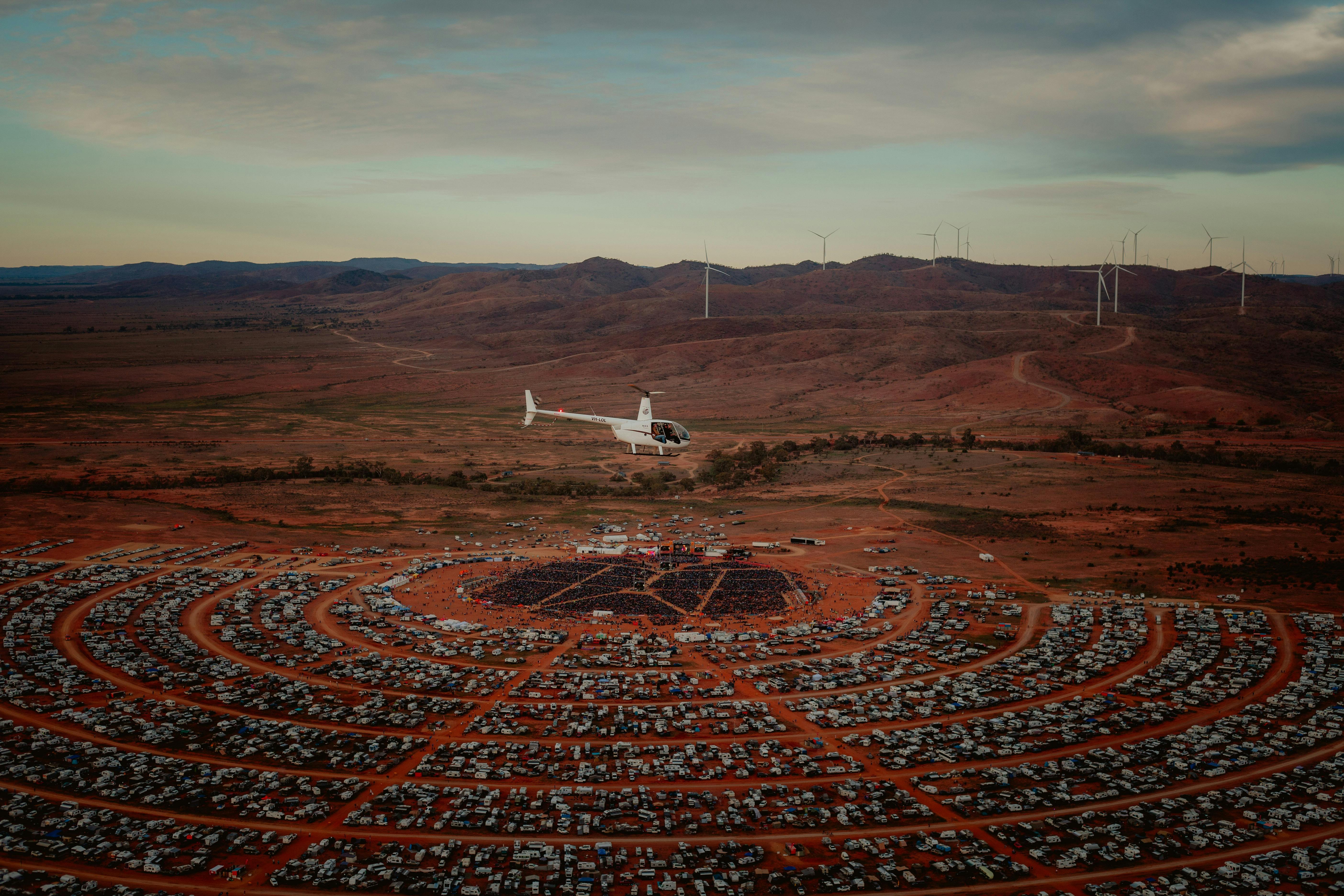 White helicopter flying over outback festival