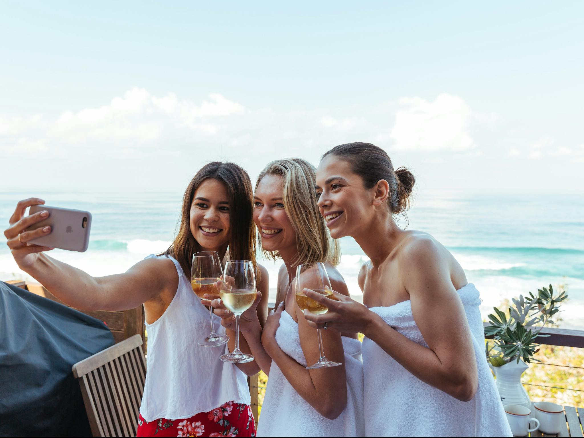 Three women taking a selfie in at a beachfront property