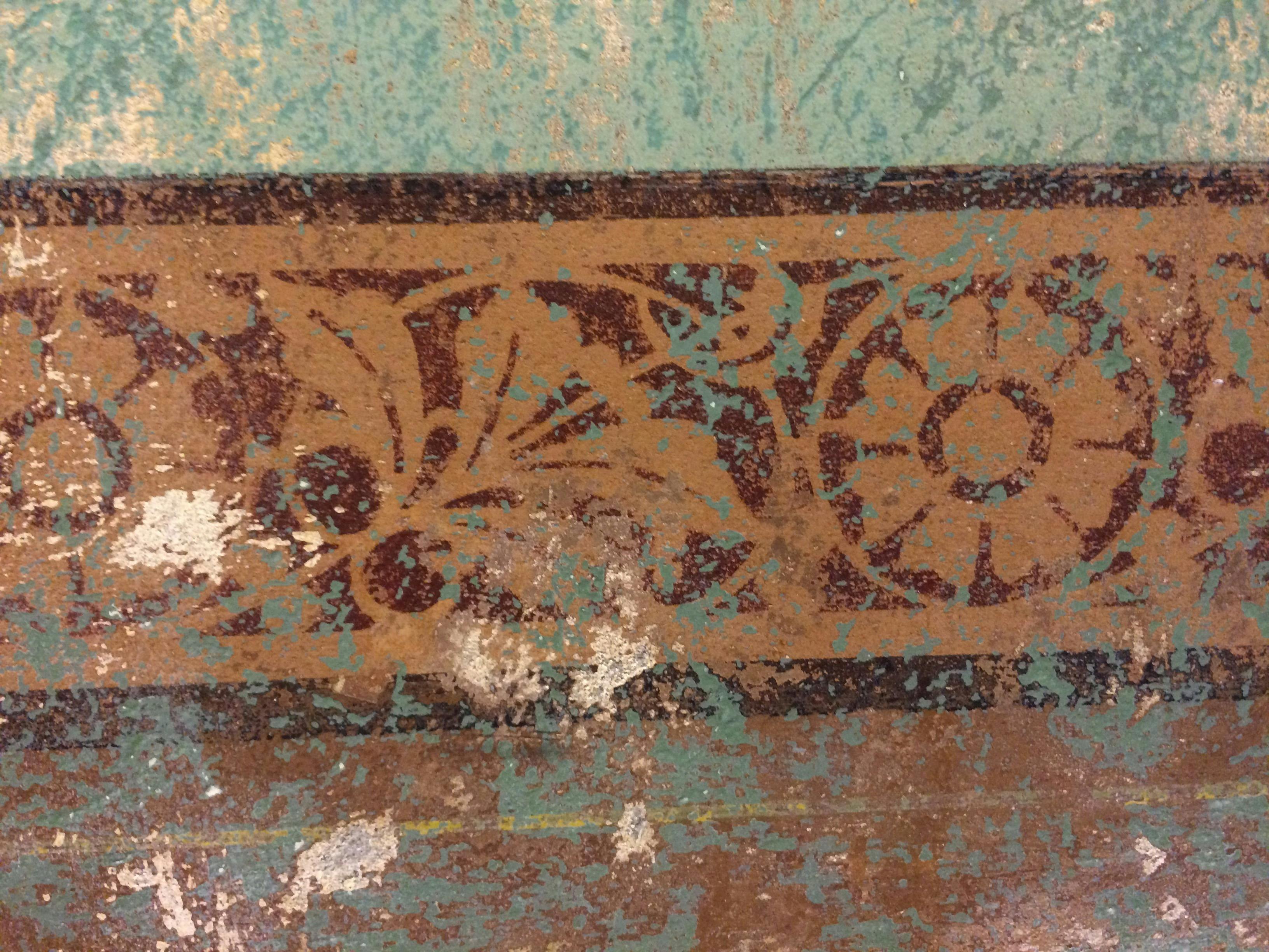 Close up photo of green and terracotta  heritage wall frieze.