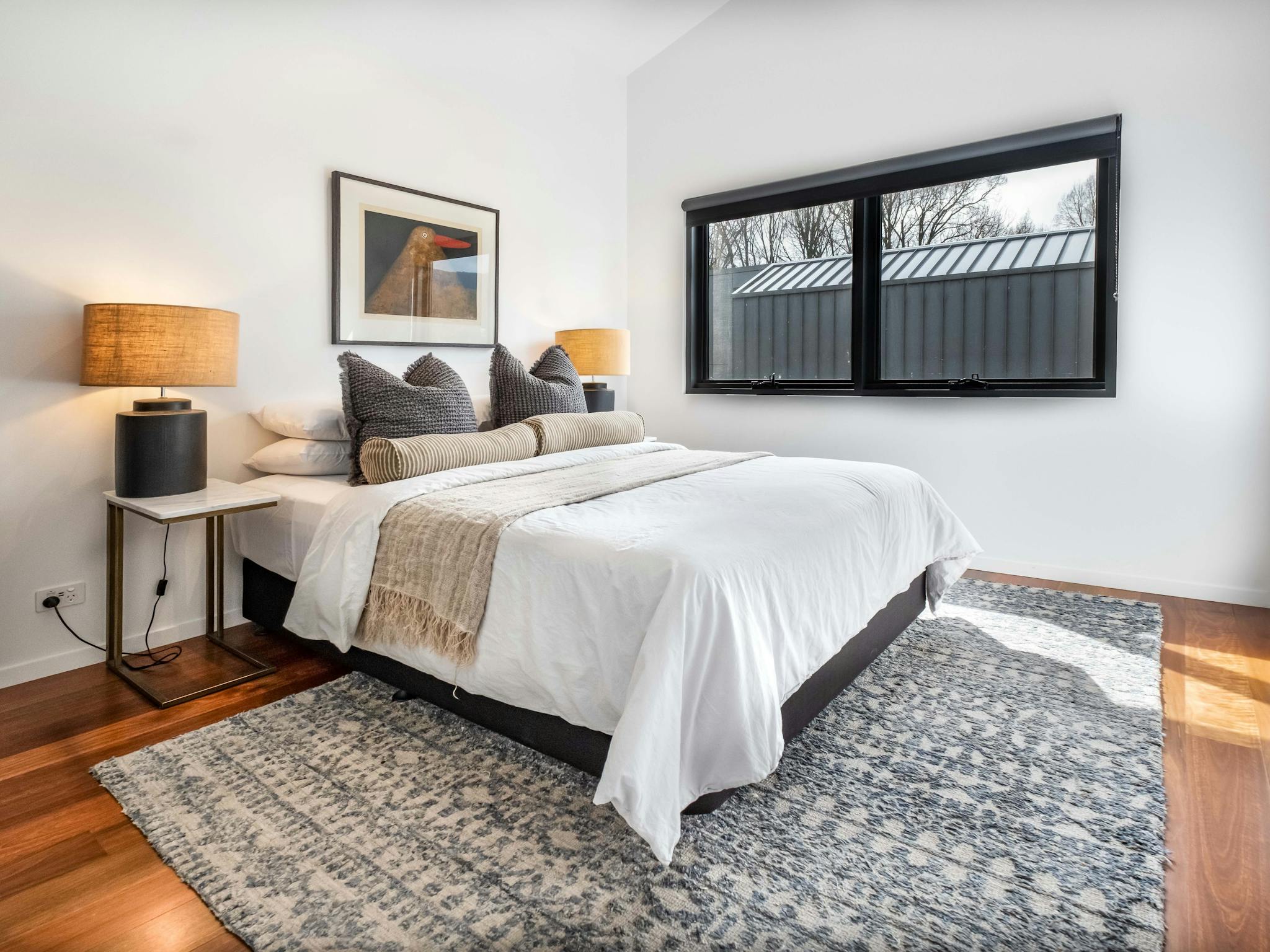 Olsen Penthouse bedroom with bed, tableside lamps and window