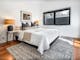 Olsen Penthouse bedroom with bed, tableside lamps and window