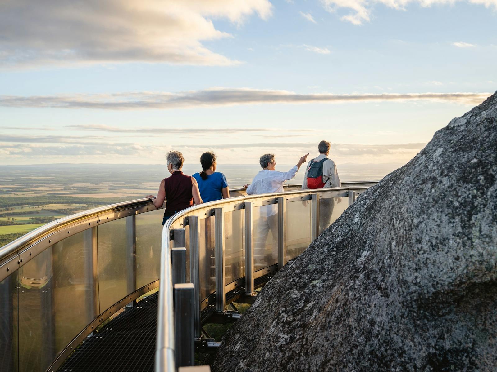 four people on elevated platform with view across landscape