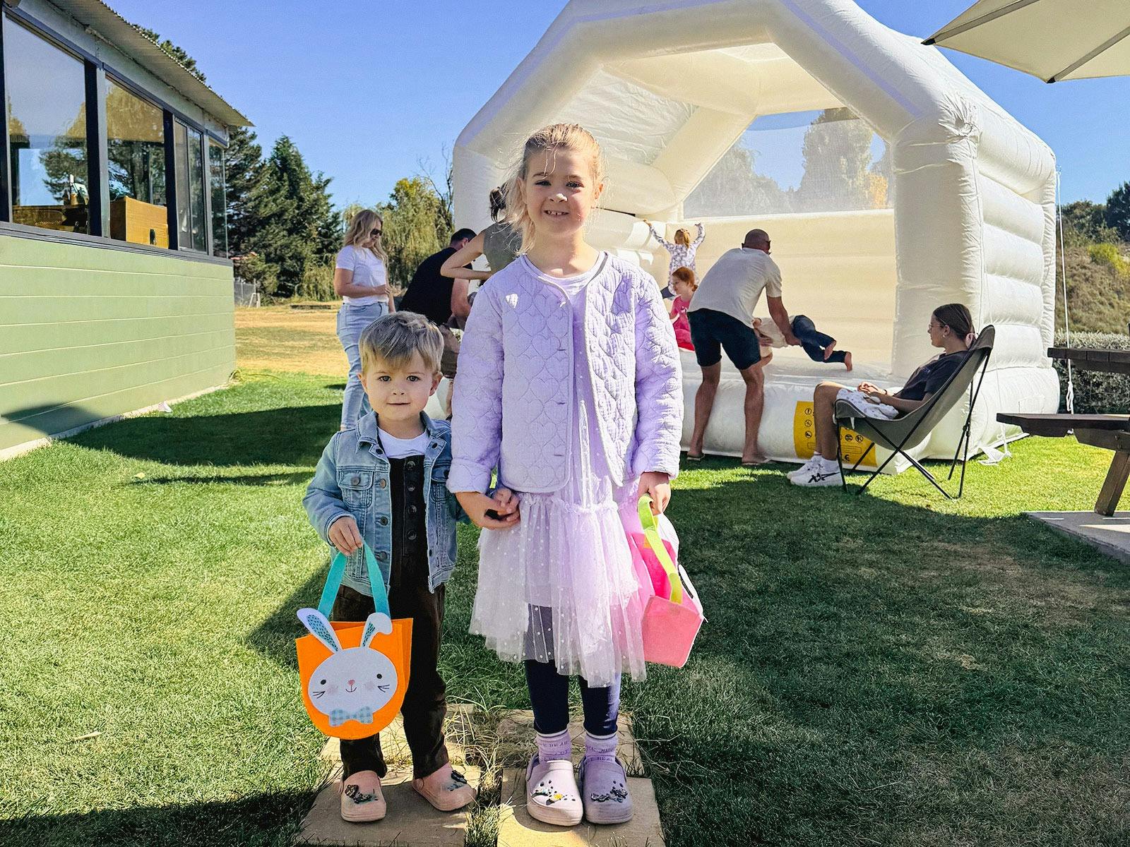 2 children with Easter hunt bags, smiling for the camera at Larder & Home