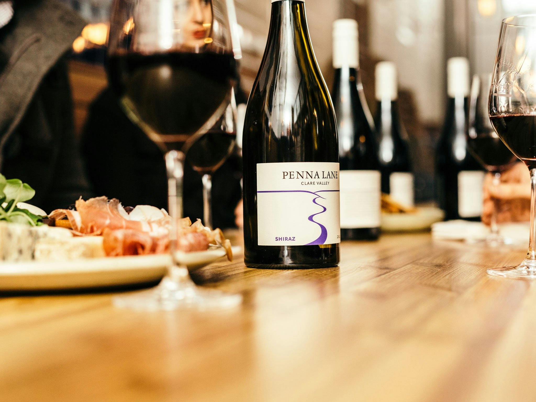 Photo of bottle of shiraz, glasses and food platter