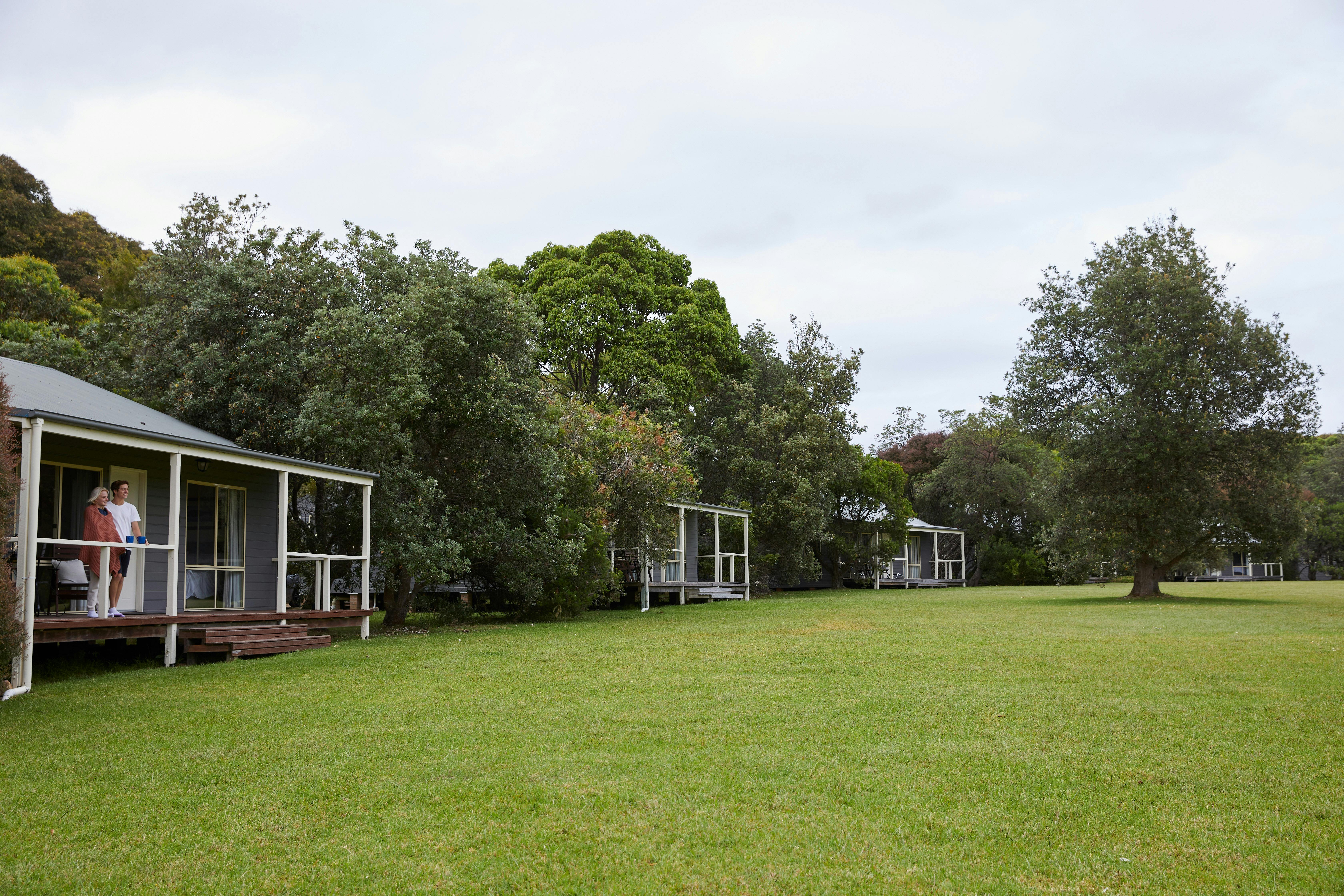 Cottages well spaced apart with trees between and all facing out onto a lawn