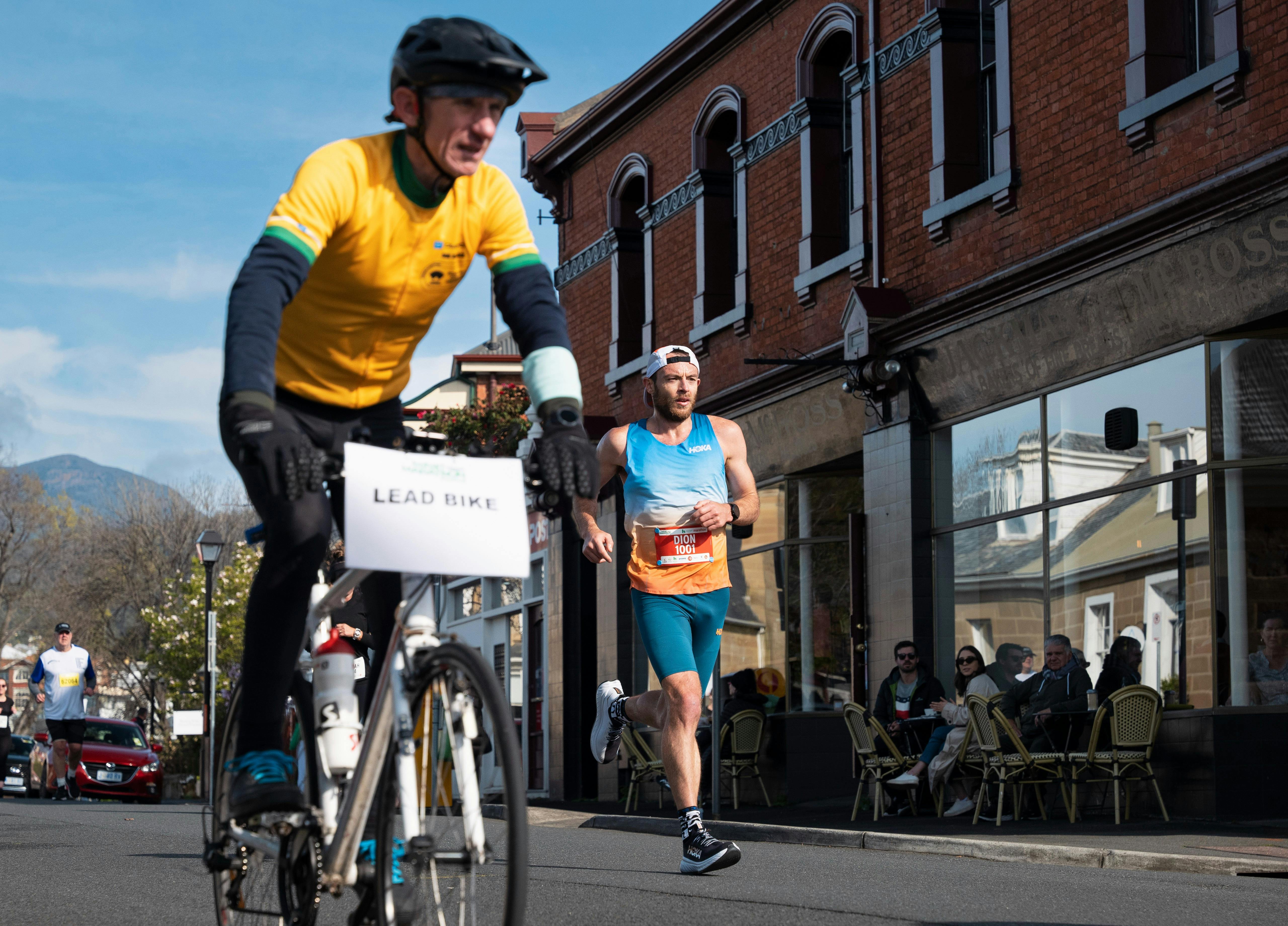 Lead marathon runner with lead cyclist in the foreground