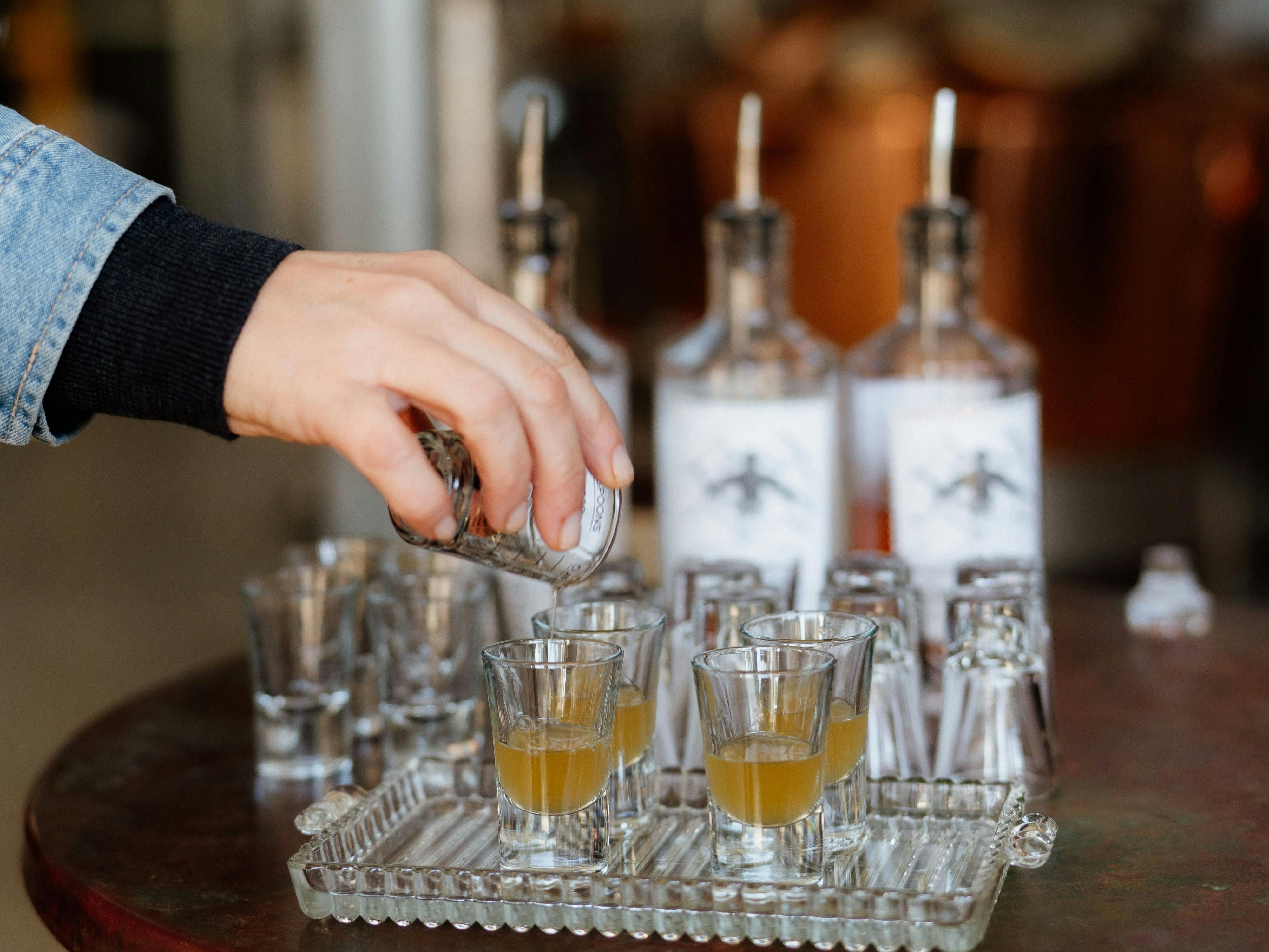 Gin is poured into small tasting glasses ready for guests to try at Swiftcrest Distillery.