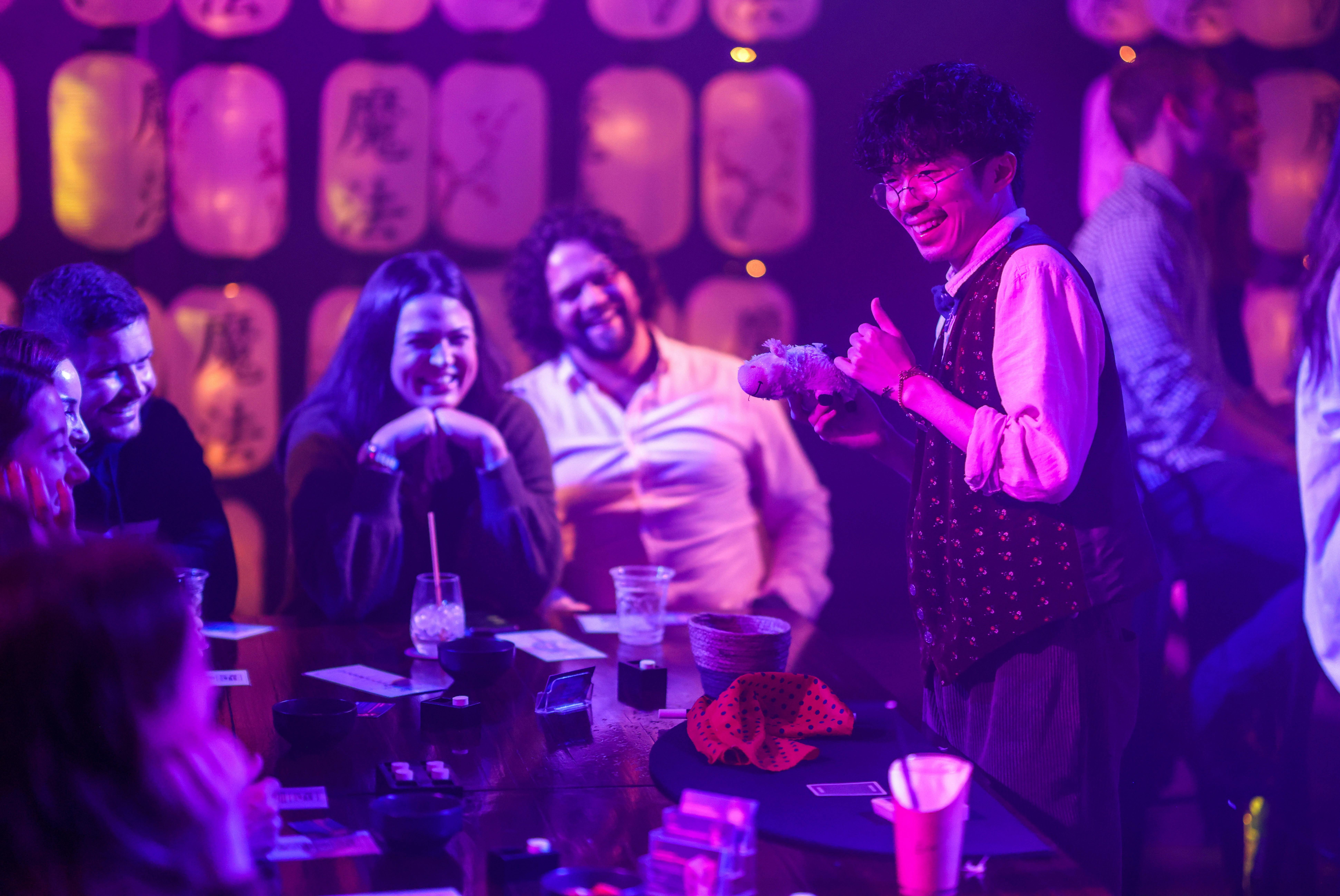 Magician with a toy prop and two smiling audience members