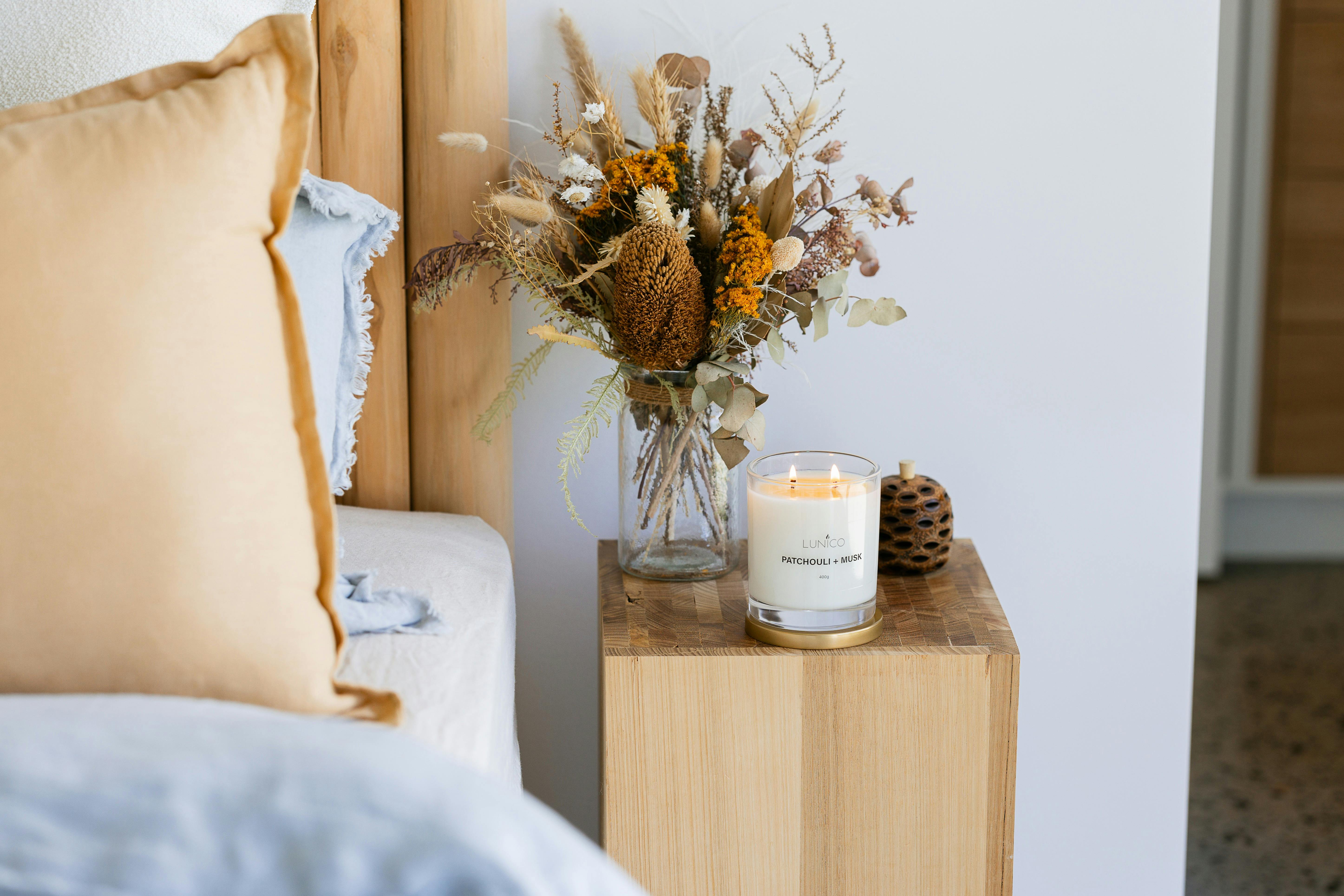 Candle burning on a bedside table.