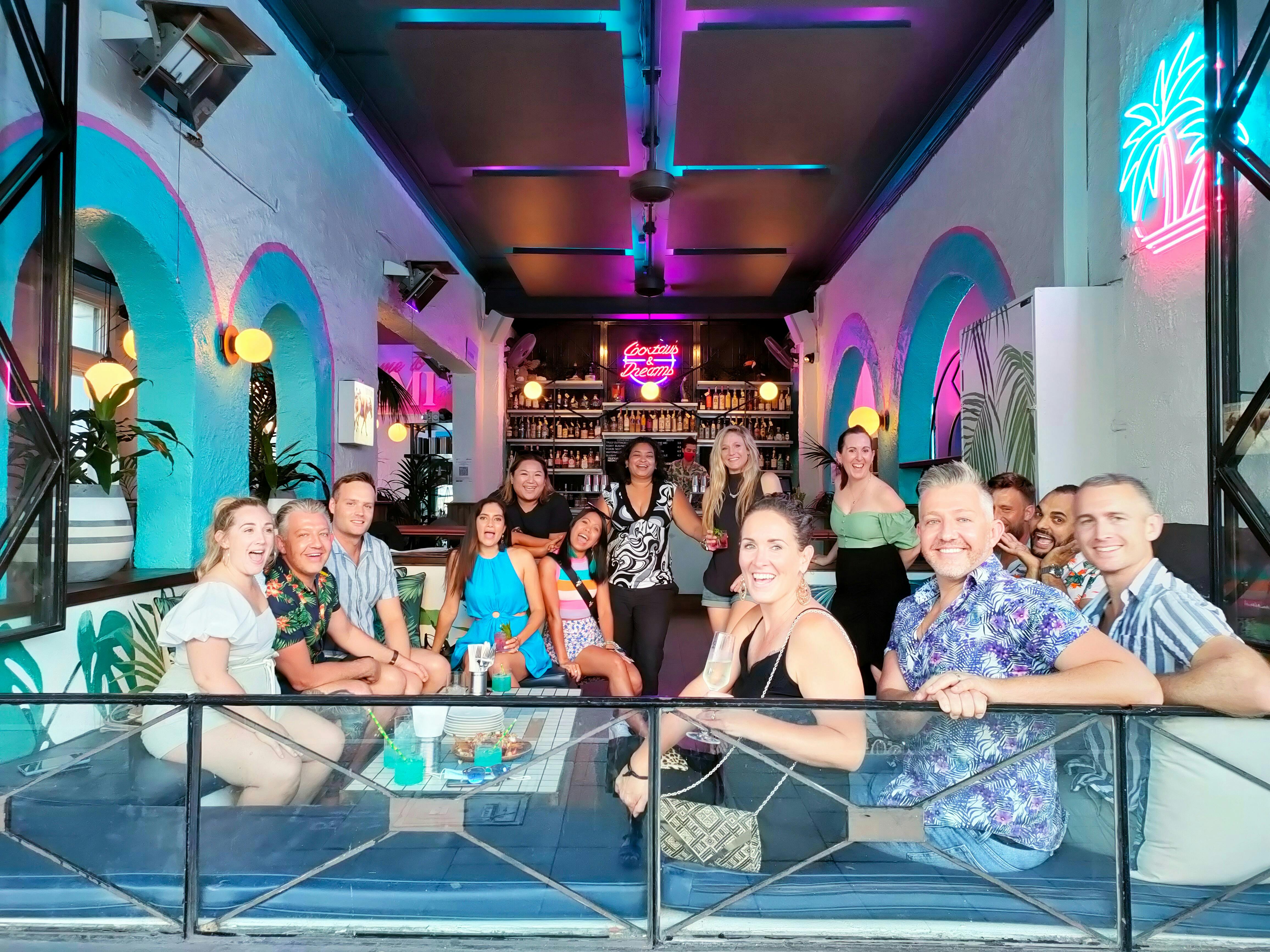a group of friends sitting in a funky, vibrant bar