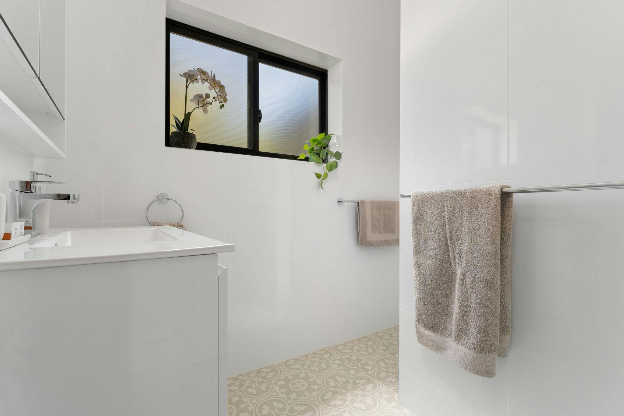 Bathroom with vanity, shower and window