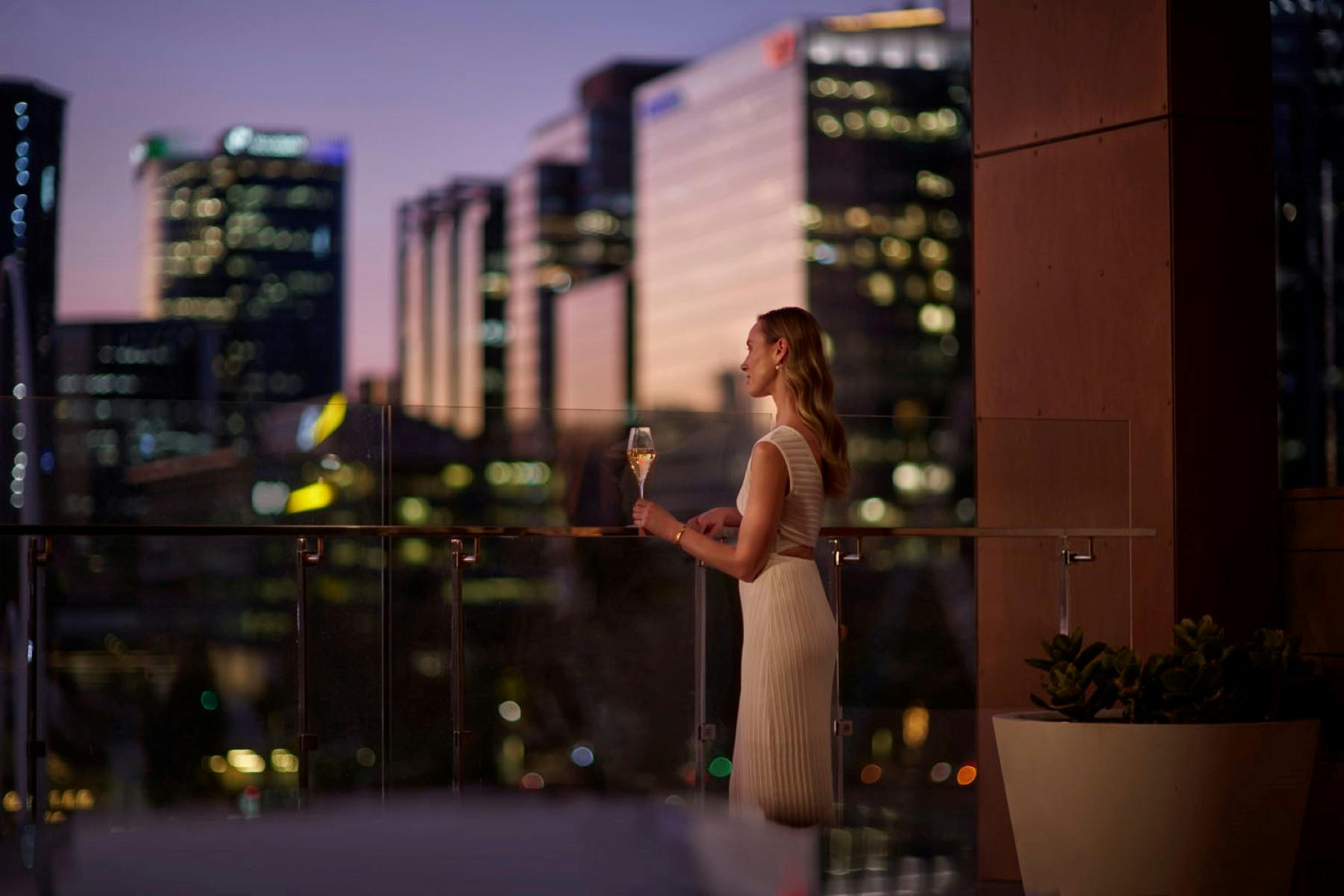 Lady enjoying a drink overlooking the sunset