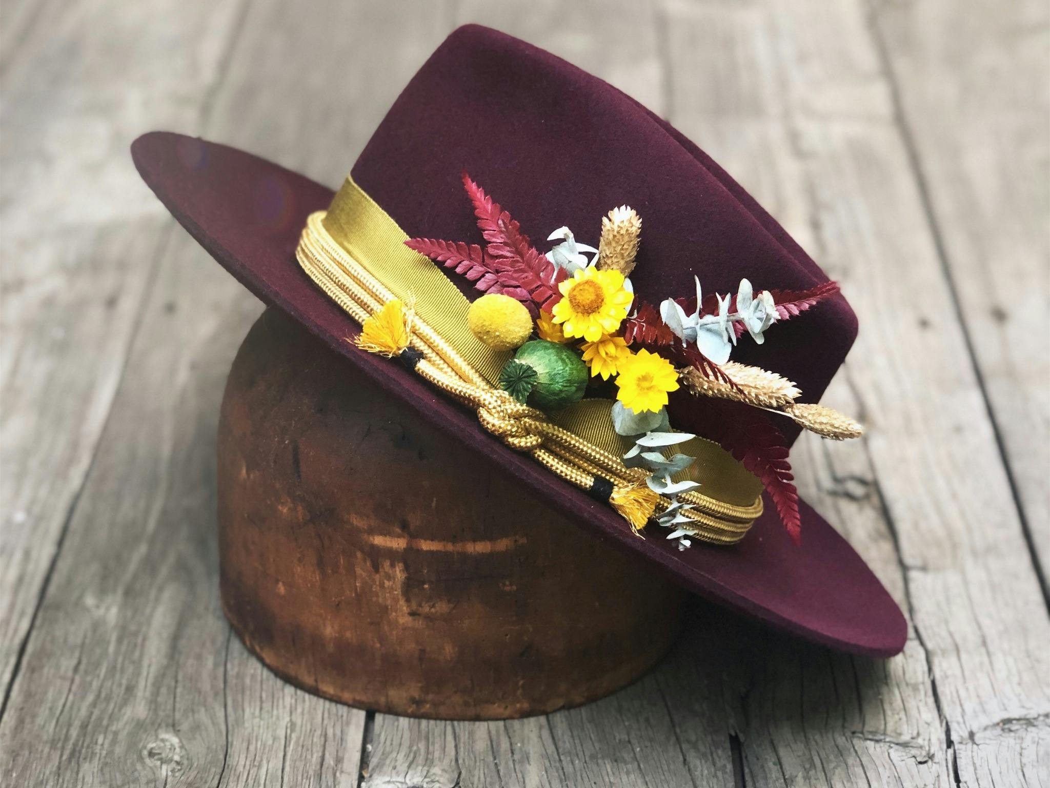 Brimmed hat with floral and ribbons design