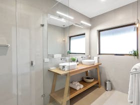 Guest bathroom at Simon Tolley Lodge with double sink and frameless shower